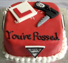 a red cake with white frosting that says you're passed and some keys on top