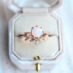 an opalite ring sits in a box on top of a white tablecloth