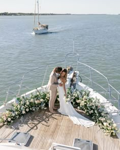 a bride and groom kissing on the deck of a boat