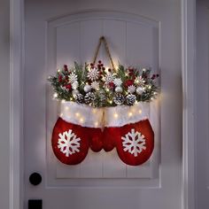 christmas stockings hanging on the front door decorated with lights and snowflakes,