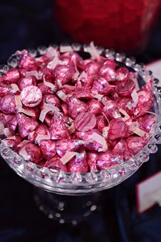 a bowl filled with pink candy on top of a table