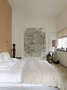 a bedroom with a large painting on the wall