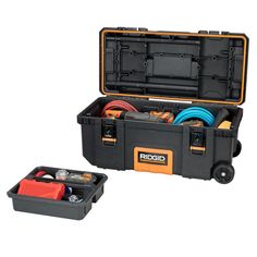 an open tool box filled with tools on wheels and hoses in the bottom compartment