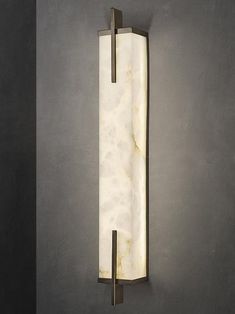 a wall light that is mounted to the side of a wall with a marble block on it