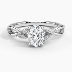 a white gold engagement ring with an oval cut diamond in the center and twisted band