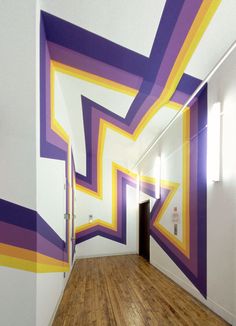 an empty hallway painted with purple and yellow stripes