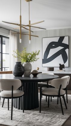 a dining room table with chairs and vases on it in front of a large painting