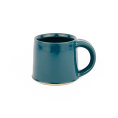 a blue coffee mug sitting on top of a white table