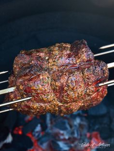 meat being cooked on skewers over an open fire