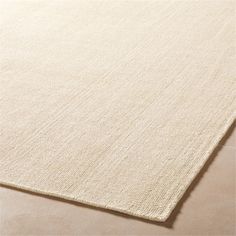 a white rug on top of a beige floor