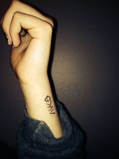 a woman's arm with a small tattoo on the left side of her wrist