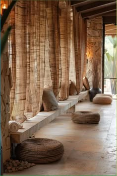 an outdoor area with stone walls and flooring, covered in natural materials such as bamboo