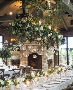 an image of a table setting with candles and greenery on the fireplace mantel