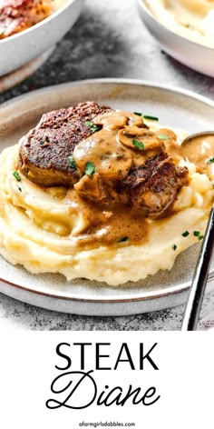 steak dinner with mashed potatoes and gravy on a white plate next to a fork