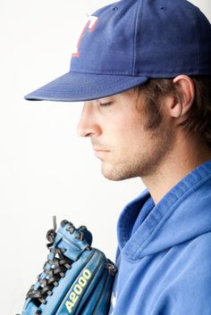 a baseball player wearing a blue hat and holding a catchers mitt