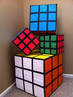 three rubik cubes stacked on top of each other in the corner of a room