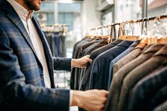 a man in a suit and tie looking at shirts