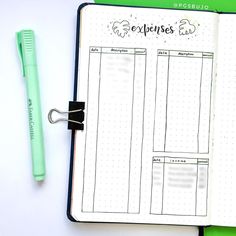 an open planner with a green pen next to it