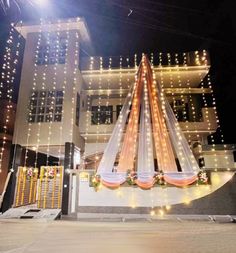 the building is decorated with lights and garlands for an event or wedding in front of it