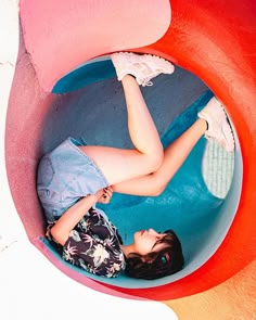 a woman laying on top of a blue and red object