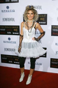 a woman in a white dress and black gloves on the red carpet at an event