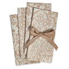 three napkins tied together with a brown bow on top of each one in front of a white background