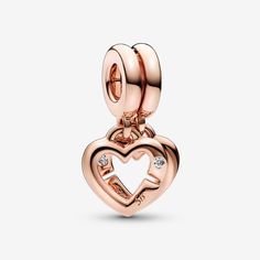 Show off your sisterly bonds with the Linked Sister Hearts Split Dangle Charm. Finished in warm 14k rose gold plating, this charm includes two linked open hearts, each featuring a sparkling clear cubic zirconia stone and engraving (one says "Sis" and the other reads "Sister"). On the back, each heart has small heart-shaped cut-outs and is engraved with "I will always have a friend". The hearts can be separated, so one can be gifted to your sister –a reminder of your forever bond. - Pandora Linked Sister Hearts Split Dangle Charm - 14k Rose gold-plated unique metal blend / Cubic Zirconia / Clear Bond Style, Sisters By Heart, Bracelet Pandora, Rose Gold Heart, Custom Pendants, Pandora Bracelets, Engraved Necklace, Small Heart, Dangle Charms