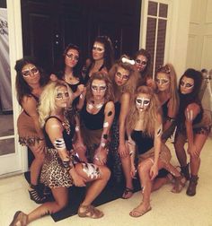 a group of women posing for a photo in front of a door with their faces painted