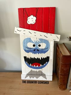 a wooden sign that has been painted to look like a monster with teeth and mouth