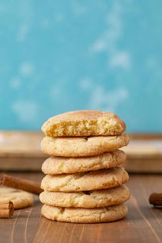 a stack of cookies sitting on top of a wooden table next to an orange and cinnamon stick