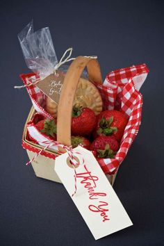 a basket filled with strawberries and cookies next to a tag