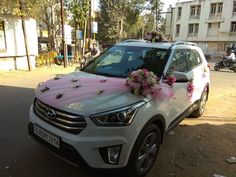 a white car with pink flowers on the hood