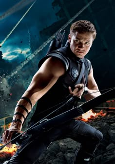 a man holding a bow and arrow in front of an image of the movie's poster