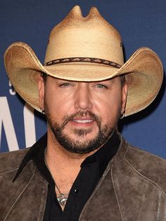 a man wearing a cowboy hat and leather jacket