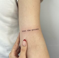 a woman's arm with the words trust the process tattooed on it