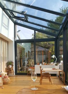 a living room filled with furniture and a glass ceiling over the dining area, next to a patio