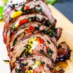 sliced meat on a cutting board with herbs