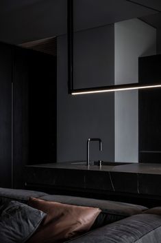 a modern kitchen with black cabinets and marble countertops is lit up by led lighting