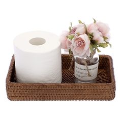 two rolls of toilet paper in a basket with flowers