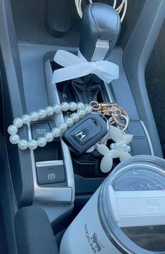 a car keychain with pearls and keys attached to it's center console