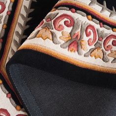 an up close shot of the back end of a black chair with red, yellow and white designs on it