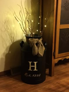 a black trash can with lights in it and a monogrammed h on the side