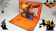 a pop up halloween card with two ghost houses on it, and bats in the background