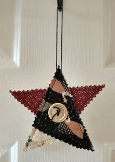 a star ornament hanging from a hook on a door with the letter c in it