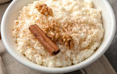 a white bowl filled with mashed potatoes topped with cinnamon