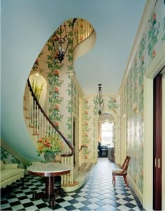 the hallway is decorated with floral wallpaper and wooden railings, along with an ornate stair case