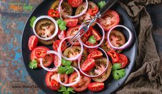 a black plate topped with sliced tomatoes and onions