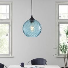 a dining room table with chairs and a light hanging from the ceiling