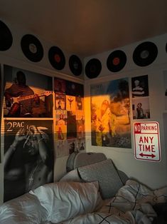 a bedroom with records on the wall and pictures above it