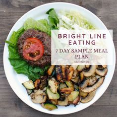 a white plate topped with meat and veggies on top of a wooden table